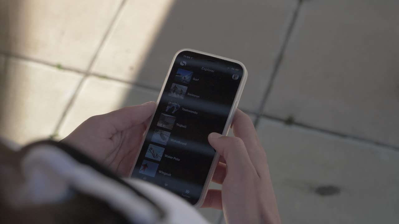 A woman chatain hair, who's scrolling her smartphone