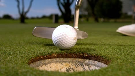 golfer putting the ball on the green