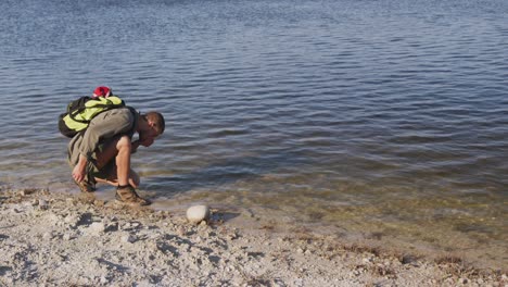 hombre caucásico junto a un lago en la naturaleza.