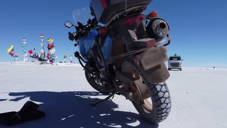 motorcycle parked on salt flat near uyuni plaza of flags in bolivia