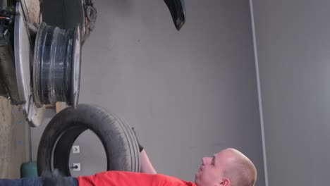 mechanic working on car tire in a garage