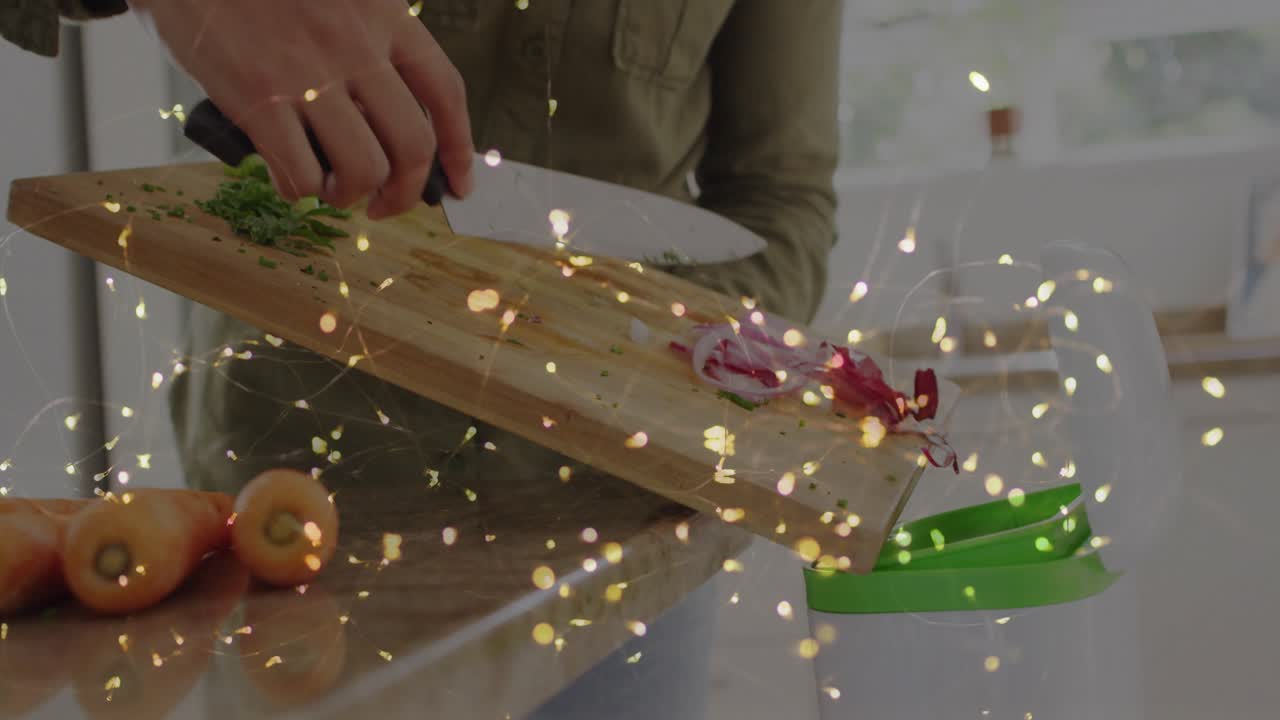 Mujer inclinando una tabla con verduras que se deslizan hacia un recipiente verde para cocinar con luces doradas