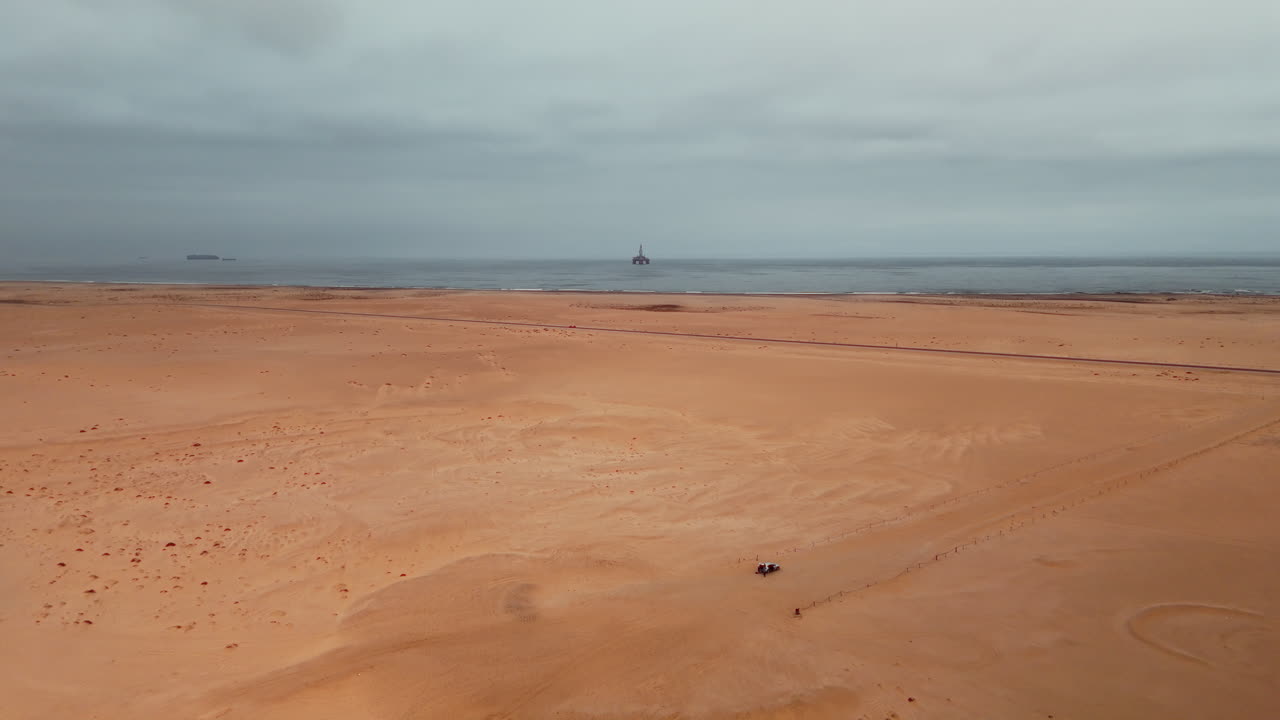 Desert Coastline with Oil Rig and People