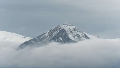 nubes de lapso de tiempo que cubren las cimas de las montañas cubiertas de nieve invierno nublado