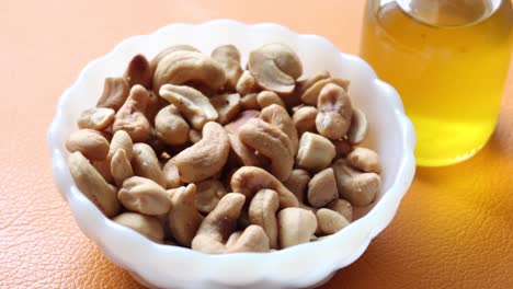 cashew nuts in a bowl and oil jar on table ,