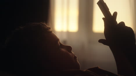 child using a smartphone in the bedroom