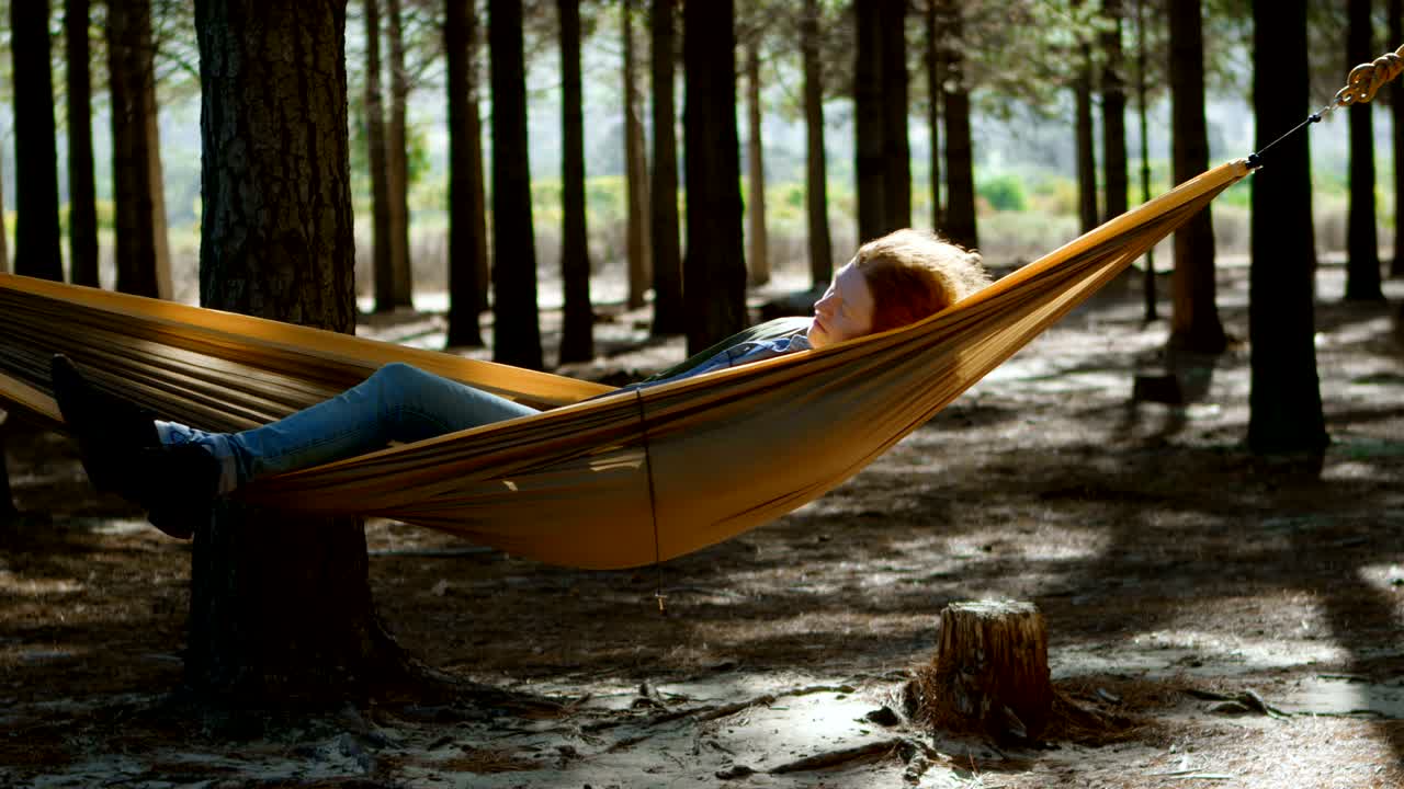 mujer durmiendo en una hamaca en el bosque 4k