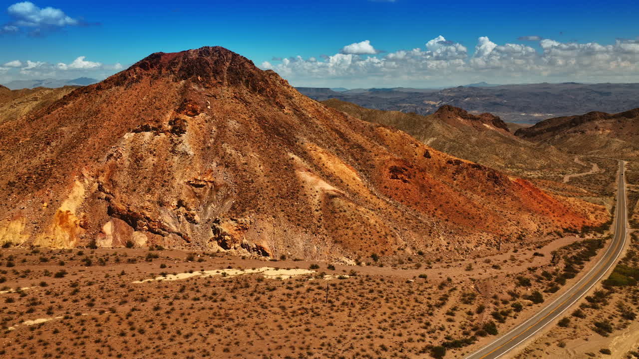 Rising above the highway at the foot of a mountain. Scenery of Mojave desert opening from the top.