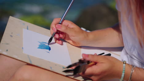 woman painting watercolor at the beach