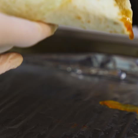 cheese shawarma with vegetables lies on a foil. grilled pita with ingredients. close up