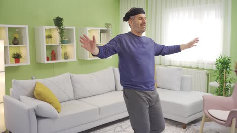 funny old man dancing alone at home, having fun, smiling.