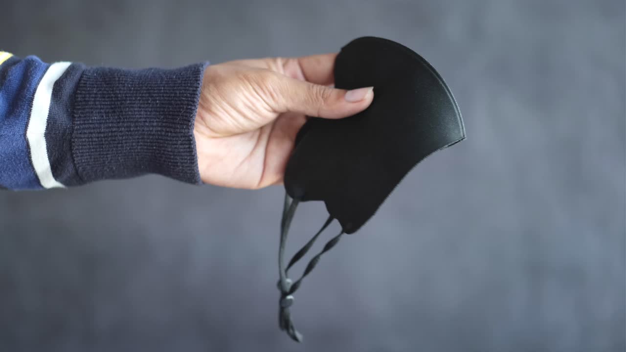 검은 마스크를 들고 있는 손