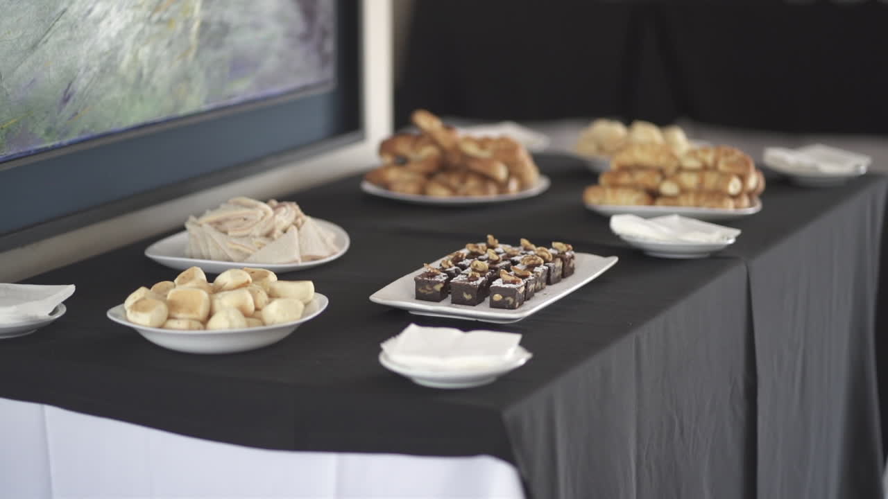 Indoor refreshment table with various pastries and sweets arranged for hotel breakfast.
