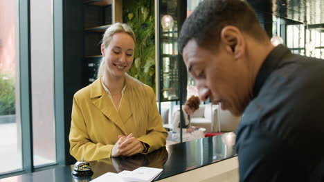 vista trasera de la recepcionista atendiendo a un invitado