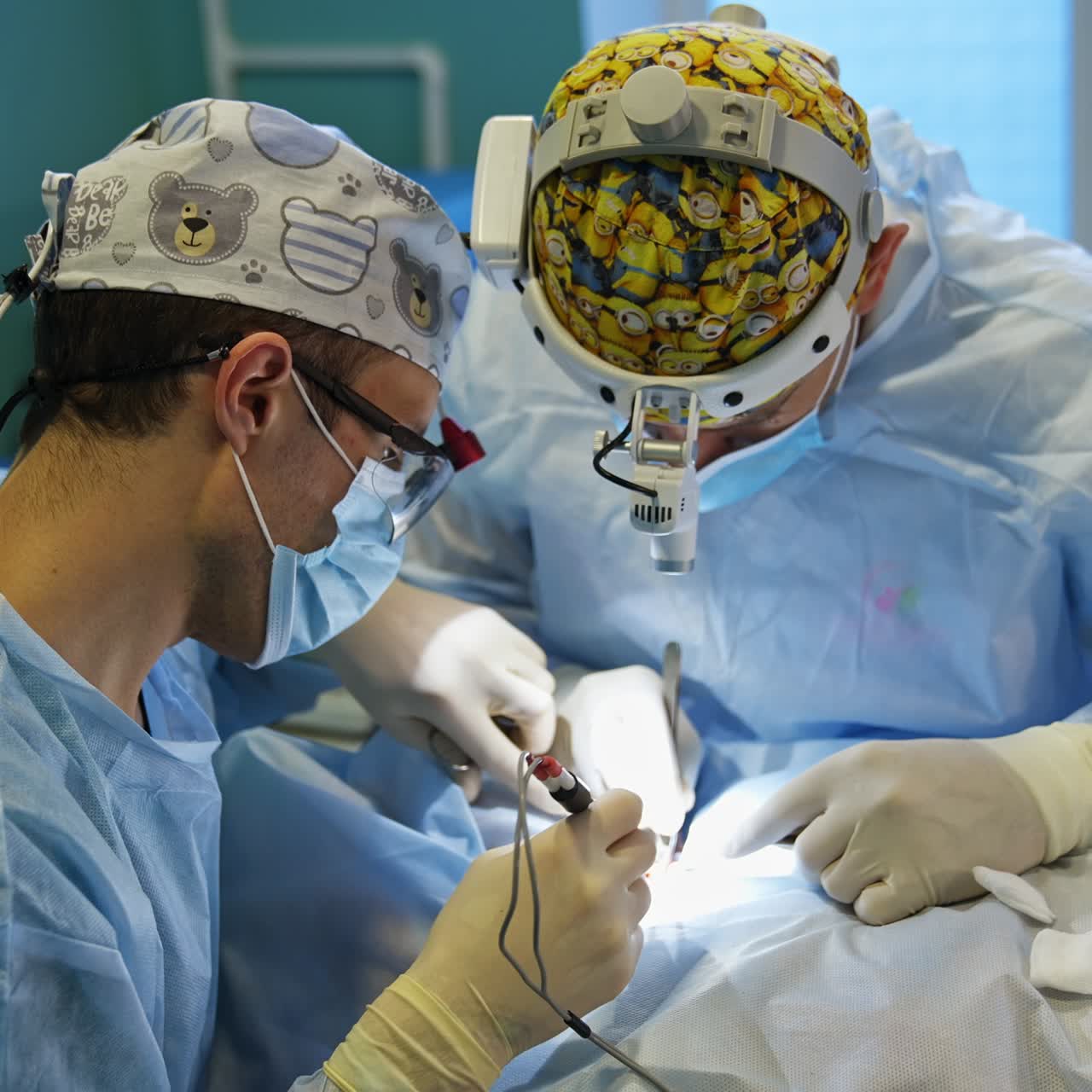 Surgery professionals apply electric tools at operation. Male doctors in caps and flashlights on heads conducting thyroid surgery