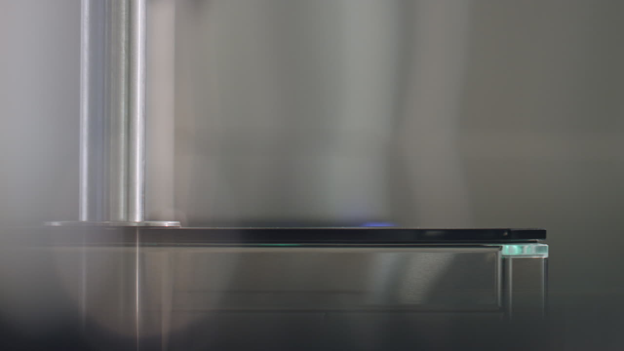 una mujer con el brazo deslizando un reloj inteligente en el panel de sensores, un torniquete electrónico de cerca.