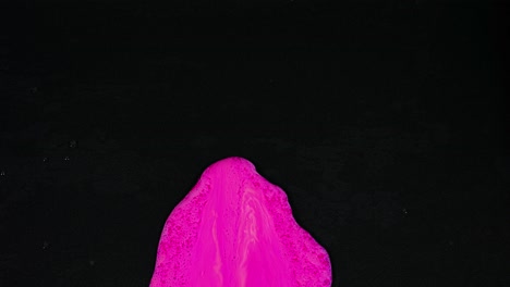 pink paint splatters on black surface