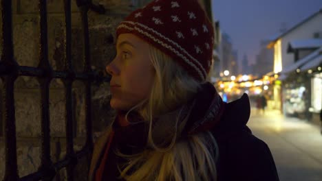 close up of blonde woman staring inside a barred window with blurry background of street in sarajevo