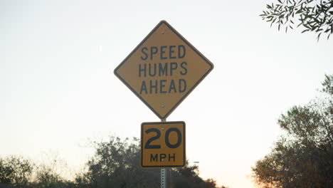 Speed humps bumps ahead street sign to make cars drive slower at 20mph