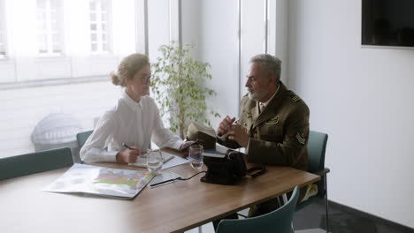 military man drinking water on an interview