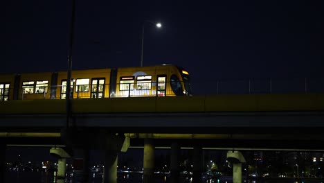 tram travels over bridge at night