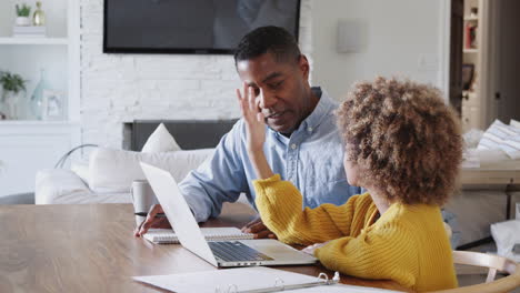 Pre-teen-African-American-girl-sitting-at-a-table-with-her-home-tutor-answering-a-question,-close-up