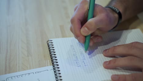 manos masculinas escribiendo en cuaderno