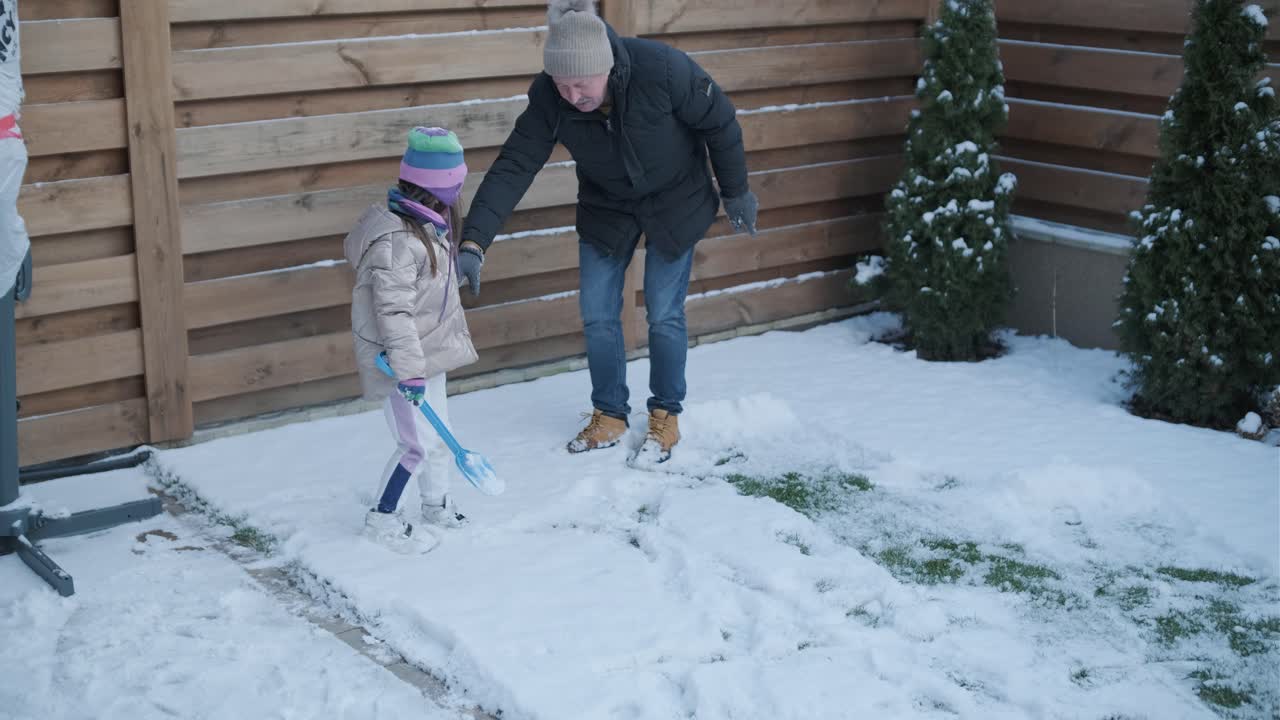 할아버지와 손녀가 눈 속에서 재미를 느끼고 있습니다.