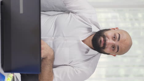 vertical video of home office worker man talking facetime looking at camera.