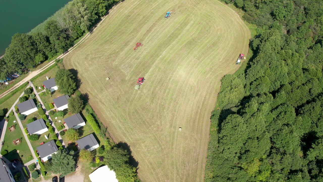 그린 필드에서 작동하는 농업 기계, 농업 농지에서 수확하는 트랙터 및 건초 베일 기계, 농장 농업 작업의 공중 하향식 보기