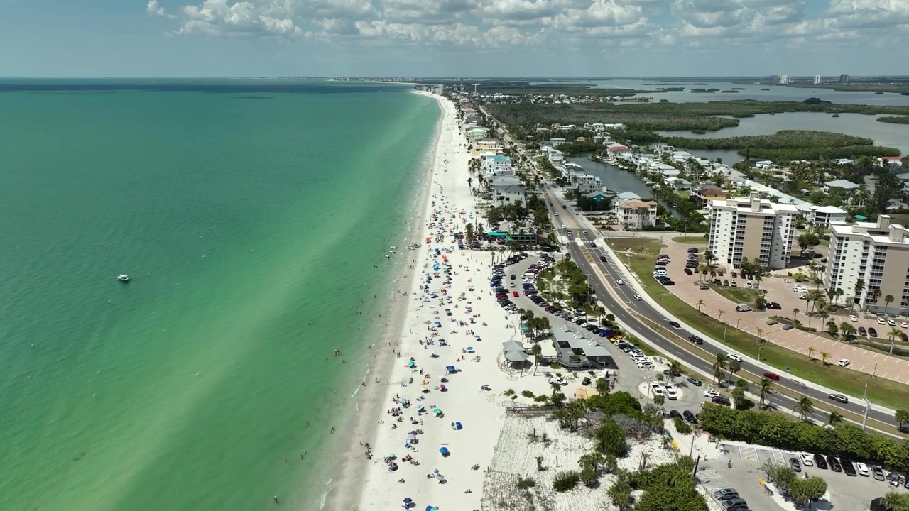 Filmato drone dall'alto di Bonita Springs, Florida, che mostra il principale corridoio della spiaggia, rigogliose mangrovie, case di lusso sui canali e paesaggi tropicali della Florida sudoccidentale.