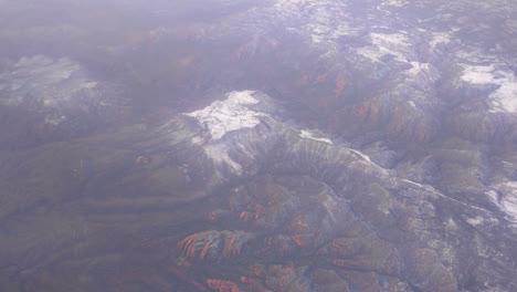 colorado mountain peaks from an airplane window with clouds during travel on a flight