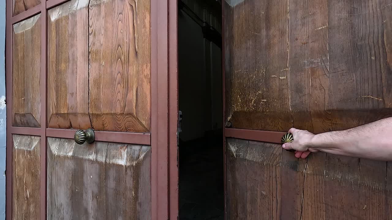 Hand opening and closing a wooden door