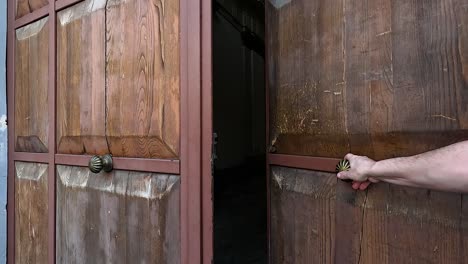 mano abriendo y cerrando una puerta de madera