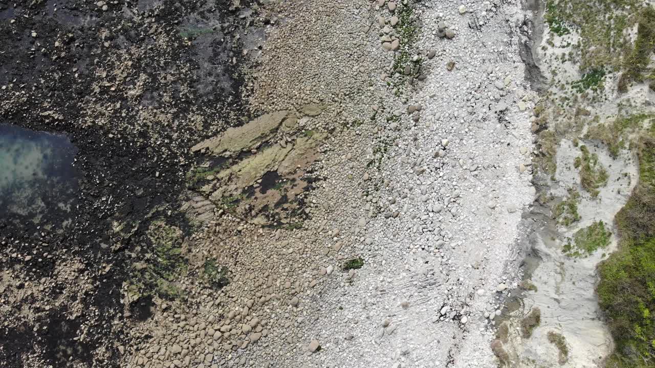 Aerial birds eye perspective showcasing the rocky coastline of Lyme Regis with Seaton undercliffs, highlighting the rugged natural beauty and geological features