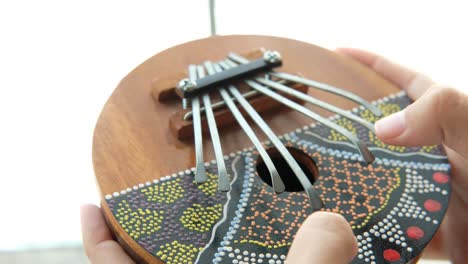 female playing a kalimba. traditional african thumb piano. african music instrument.