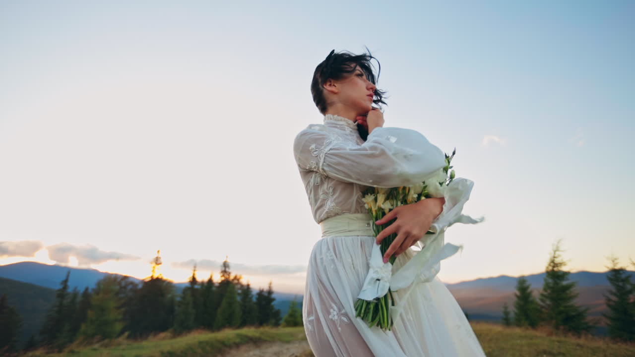 Bride in White Dress with Bouquet at Sunset Mountaintop