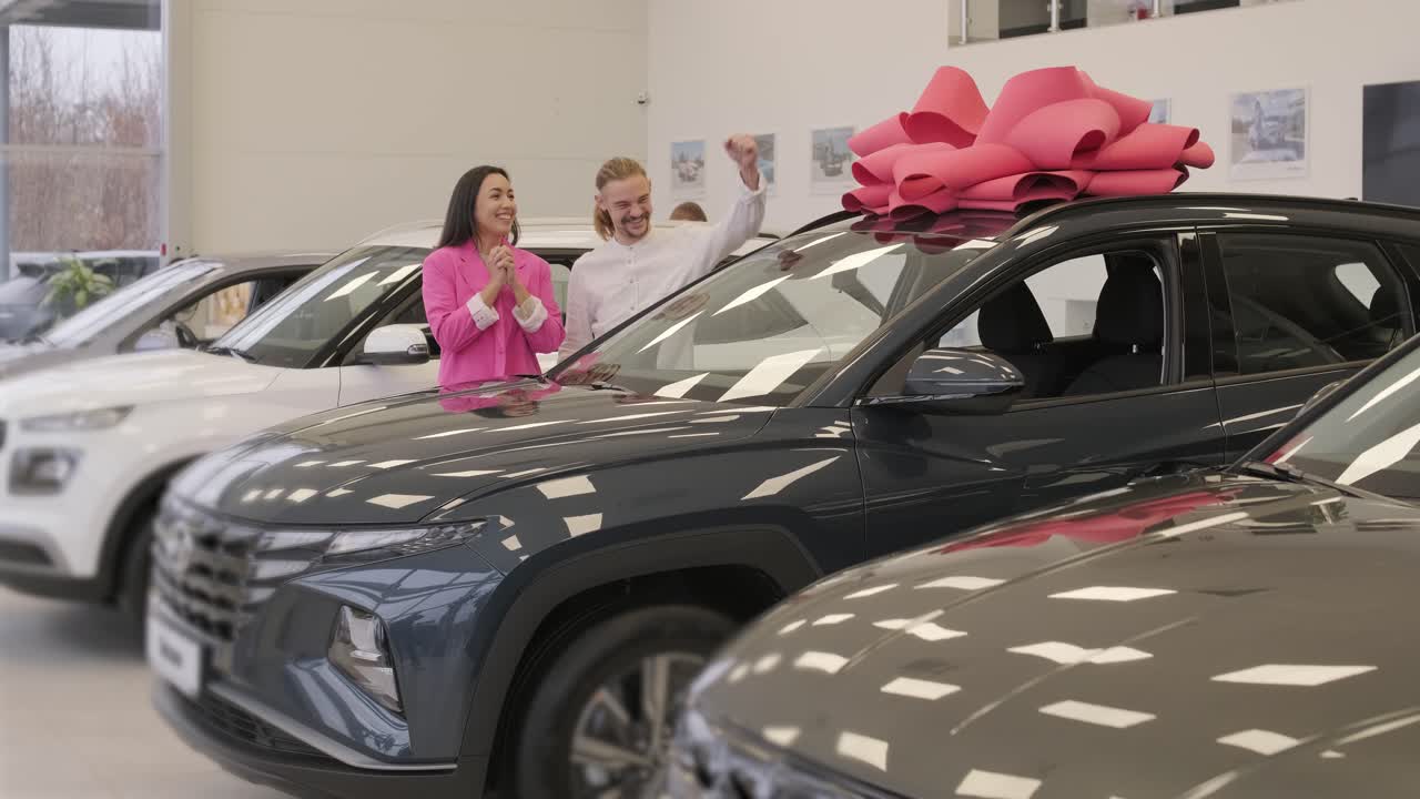 la exitosa visita al concesionario. una joven pareja feliz elige y compra un coche nuevo para la familia.