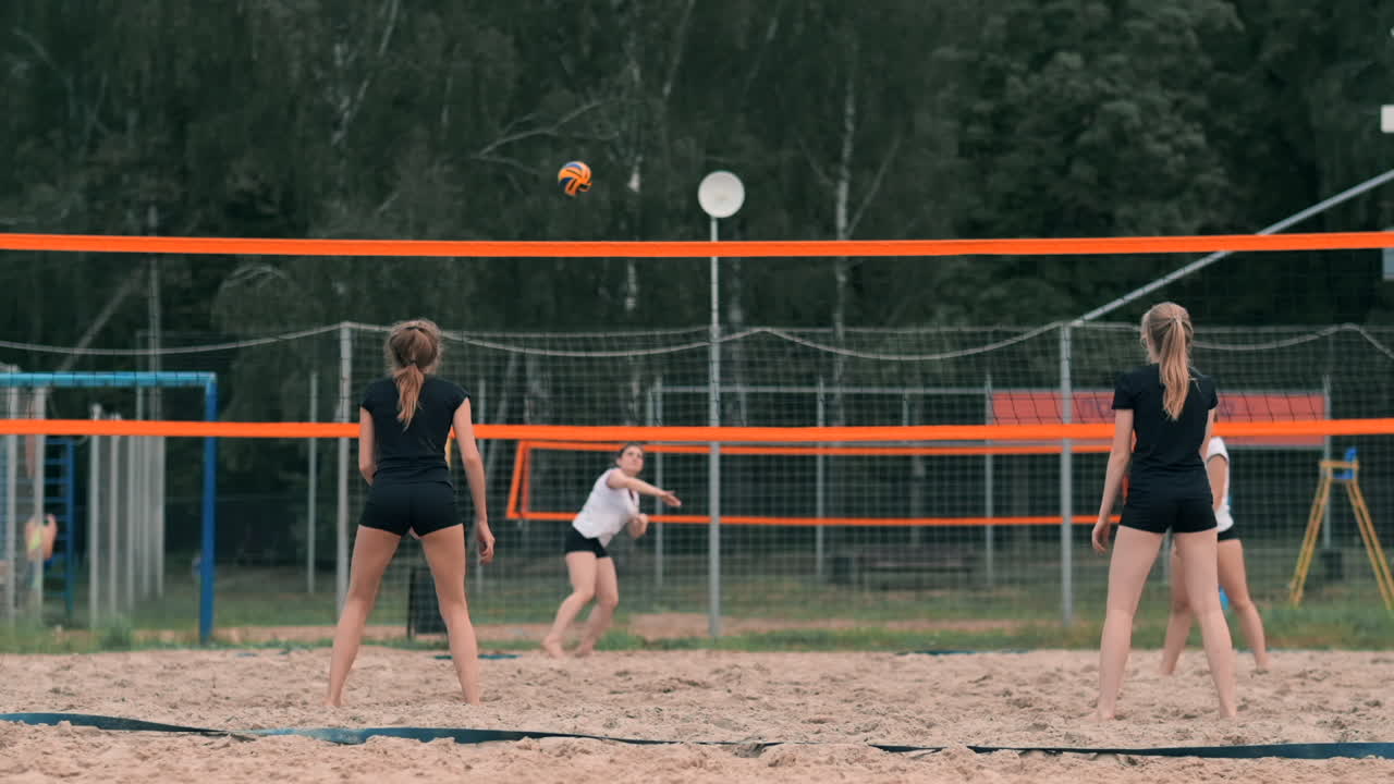 프로 해변 배구 토너먼트에서 경쟁하는 여성. 2 명의 여성 국제 프로 해변 발리볼 동안 수비수가 을 막으려고합니다.