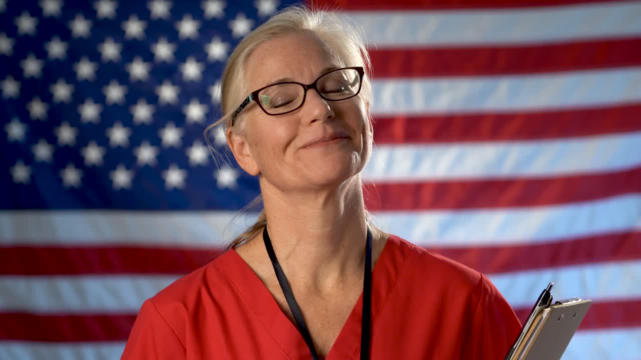 우리 깃발에서 전경으로 걸어가는 간호사의 초상화와 고개 끄덕임으로 미소와 승인을 보여줍니다