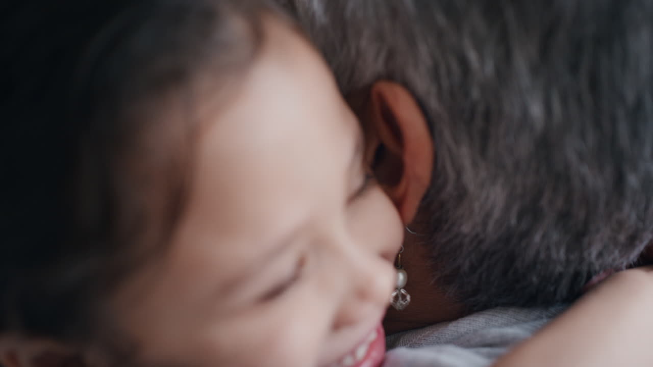 cute little girl hugging grandmother smiling embracing her granddaughter happy granny enjoying hug from her grandchild at home family concept 4k