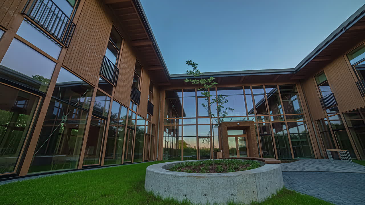 toma panorámica de un edificio de oficinas recién construido con paredes de vidrio durante el día.