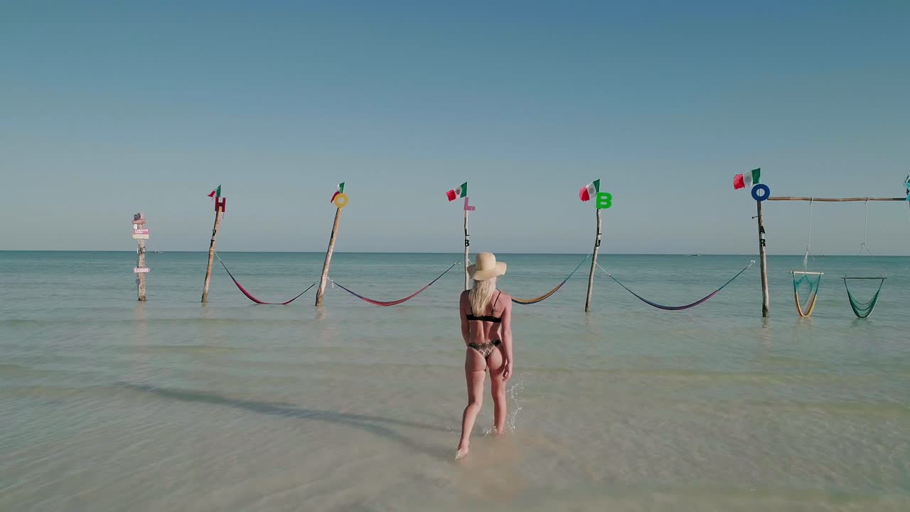 modelo de bikini con trasero redondo perfecto caminando hacia hamacas de holbox