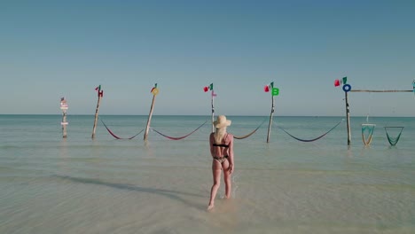 modelo de bikini con trasero redondo perfecto caminando hacia hamacas de holbox