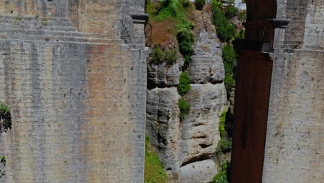 drone shot backing out from under a bridge with a concrete wall right next to it