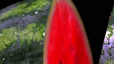 closeup of a watermelon cut in half being sprayed with water