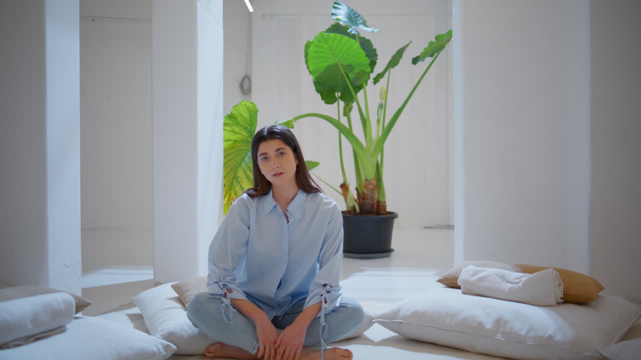 조용한 장소에서 카메라를 찾는 명상적인 여성. 평화로운 여성 앉아 lotus