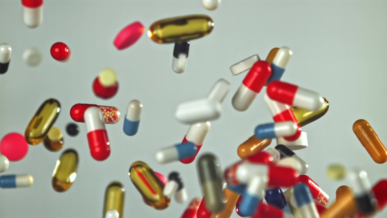 Colorful Pills and Capsules Falling in Slow Motion