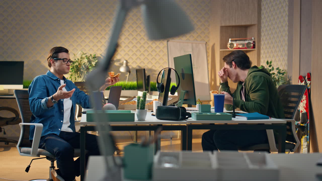 興奮したパートナーが食べ物を味わって オープンスペースで冗談を言う ピザを楽しんでいる笑う男たち