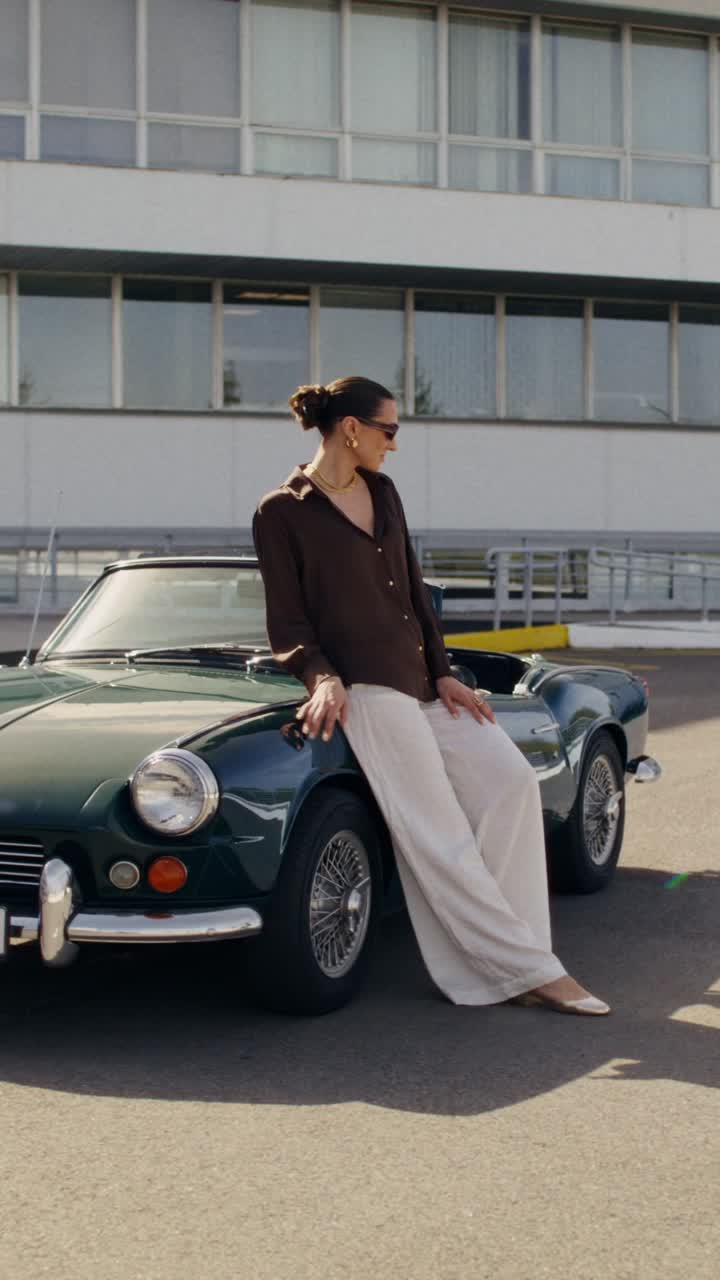 Woman posing by vintage car